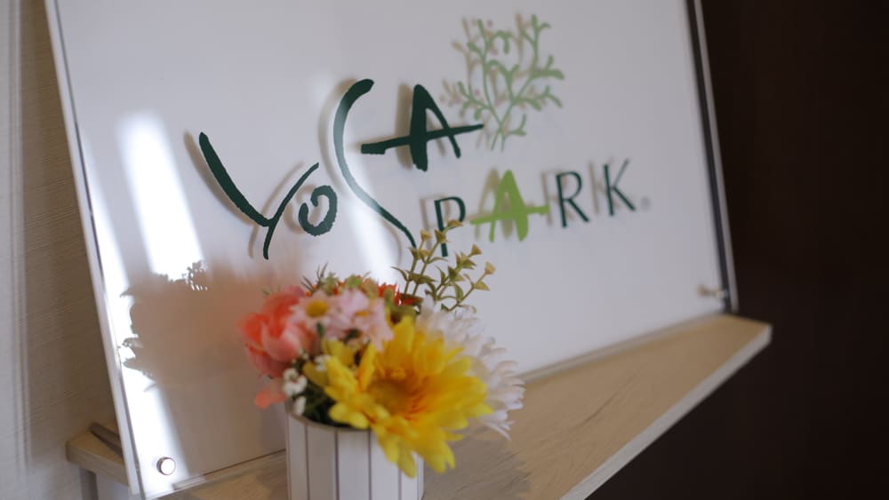 お花が添えられた YOSA PARK のサロンサイン